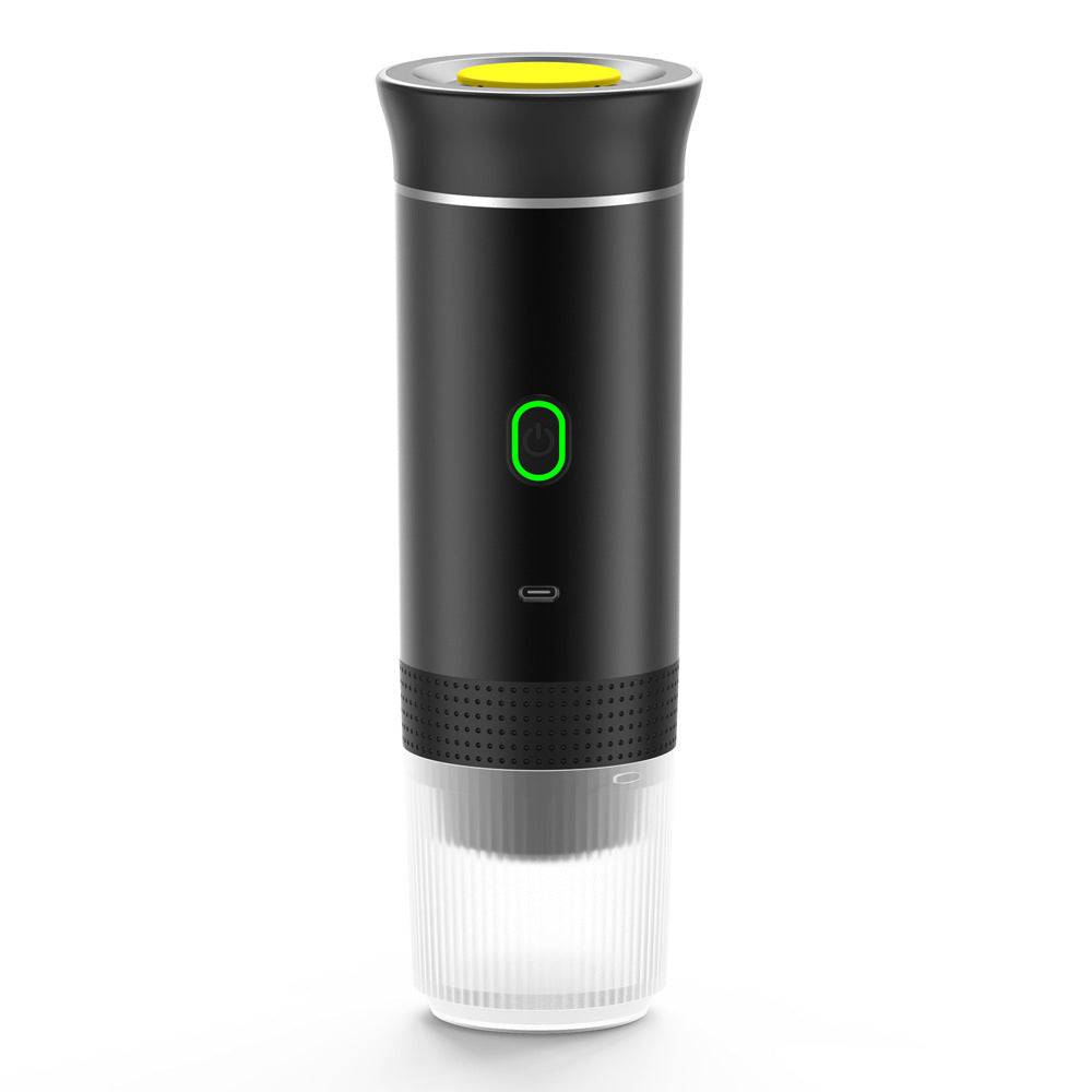 Compact black portable espresso machine with a yellow top button, green power light, and clear cup base.