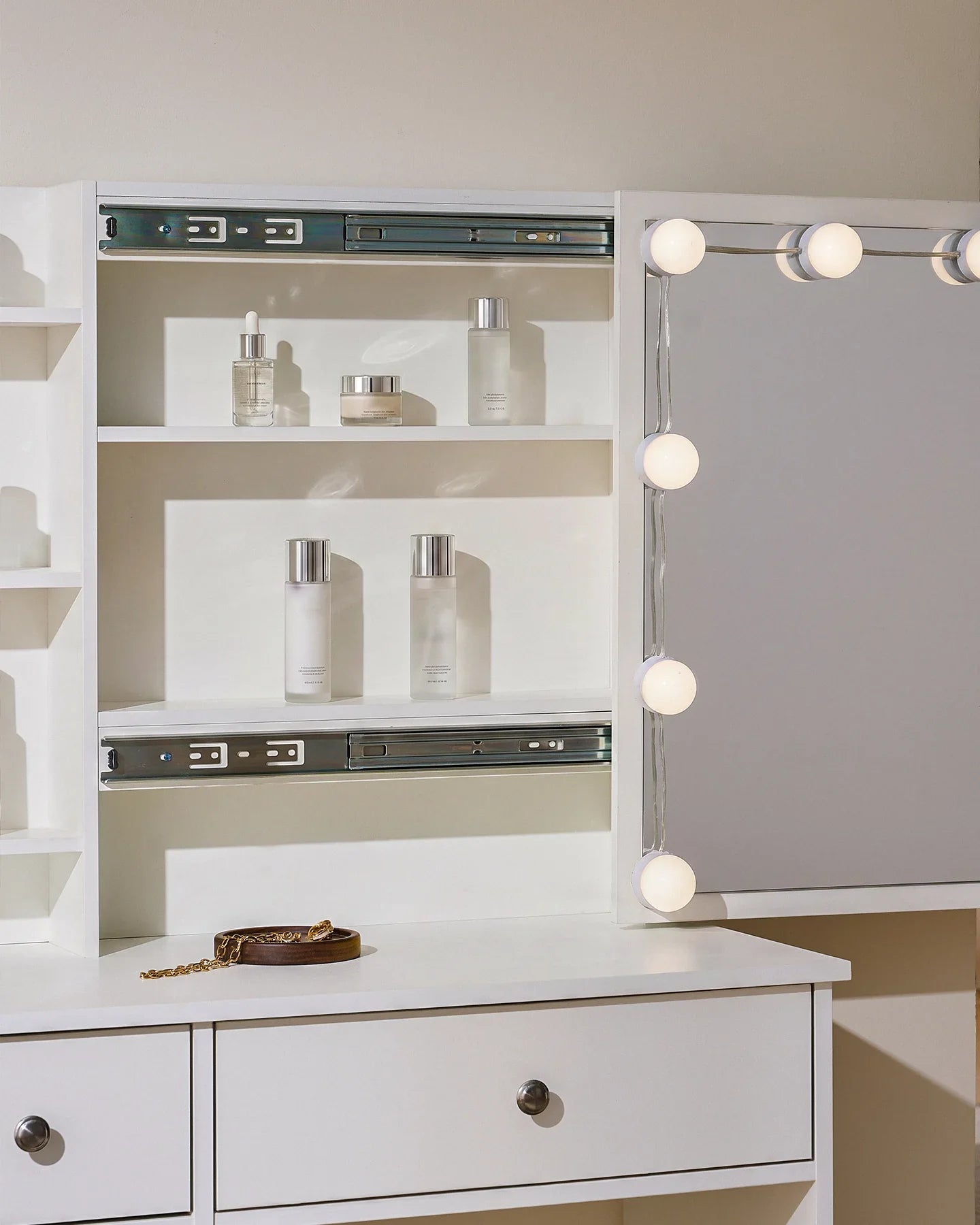 Dressing table set in white with sliding mirror, LED bulbs, and hidden storage shelves for organized beauty essentials.