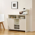 Warm white Arden Wine Bar Cabinet with fluted panel doors, brushed gold handles, open shelves, and a 6-bottle wine rack.