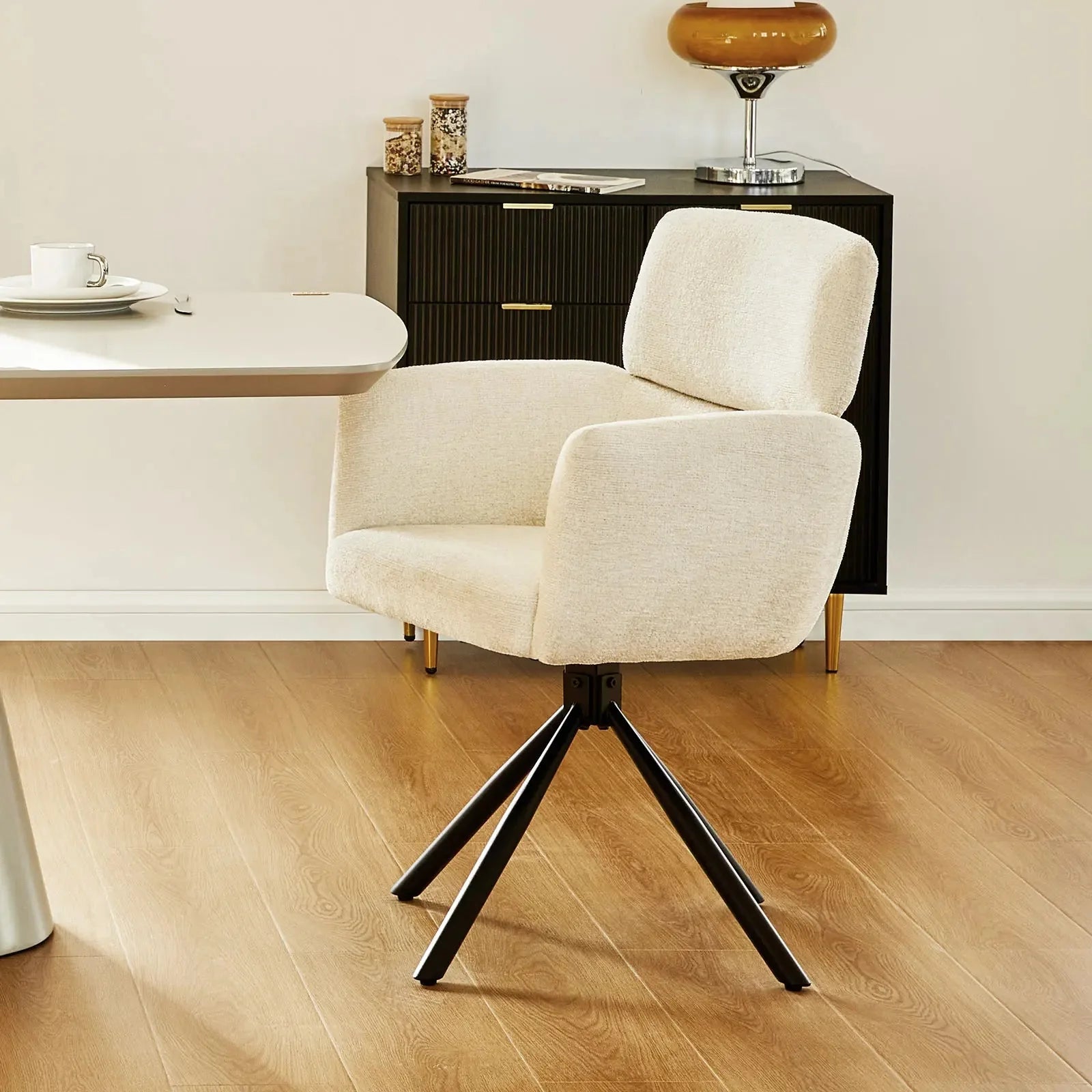 Chenille swivel chair in a creamy beige color with a sleek black metal base and a comfortable armrest design.
