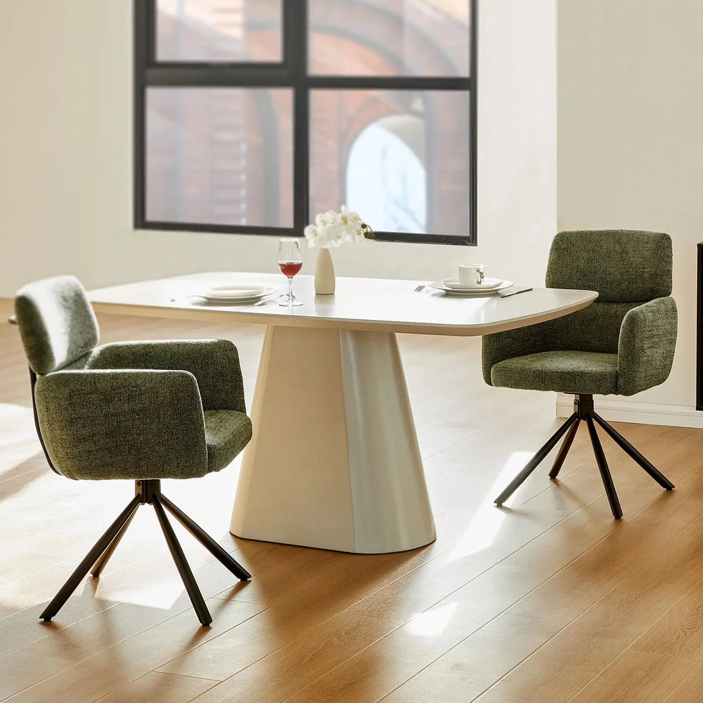 Chenille swivel chair in olive green with sleek black metal base, positioned at a modern dining table.