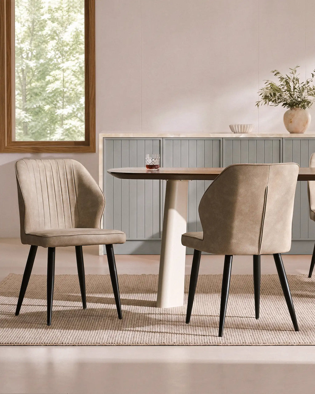 Set of 6 Danforth faux leather dining chairs in beige, featuring black metal legs and ribbed backs, arranged at a dining table.