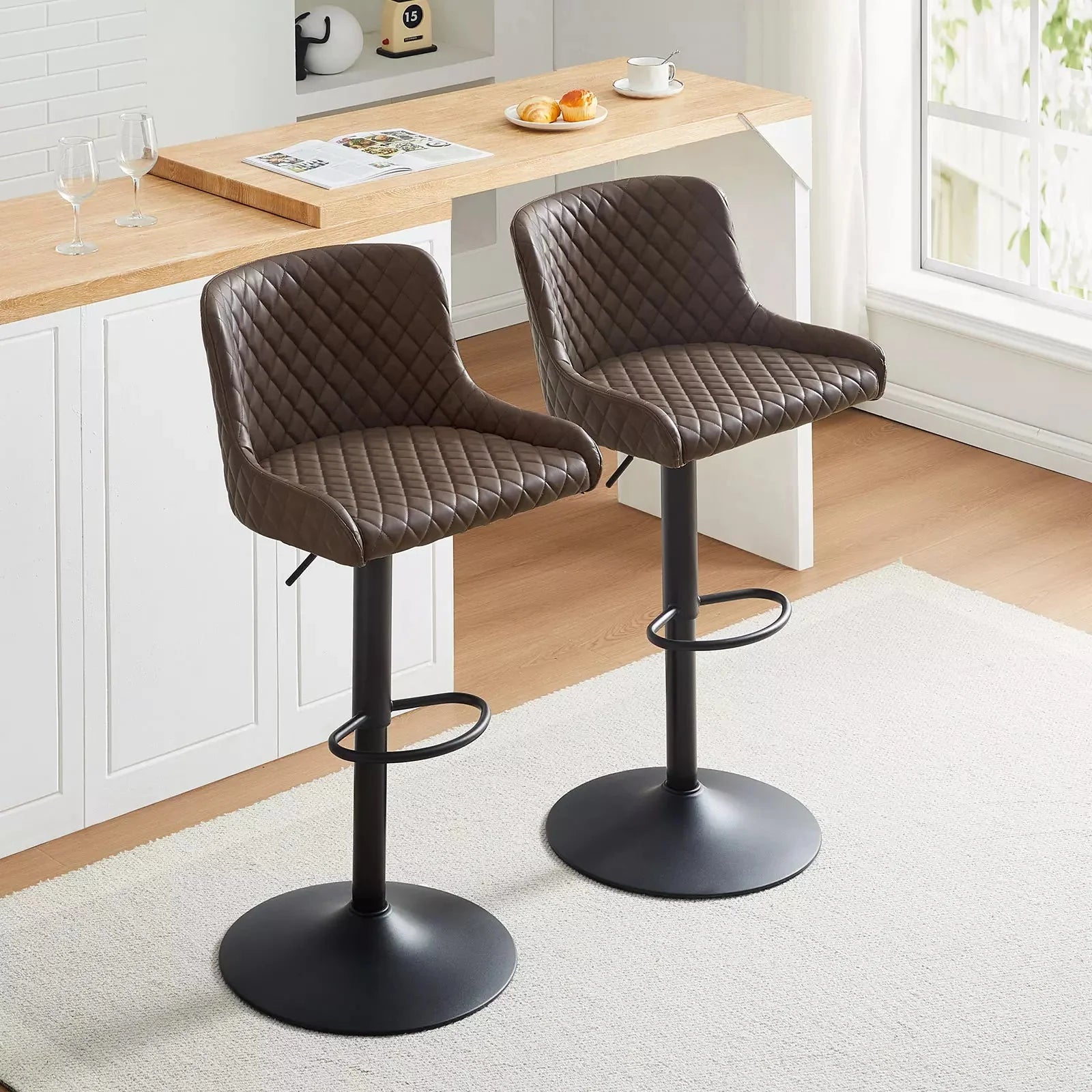 Height-adjustable Dundas faux leather bar stools in brown, featuring a quilted design, metal base, and footrest.