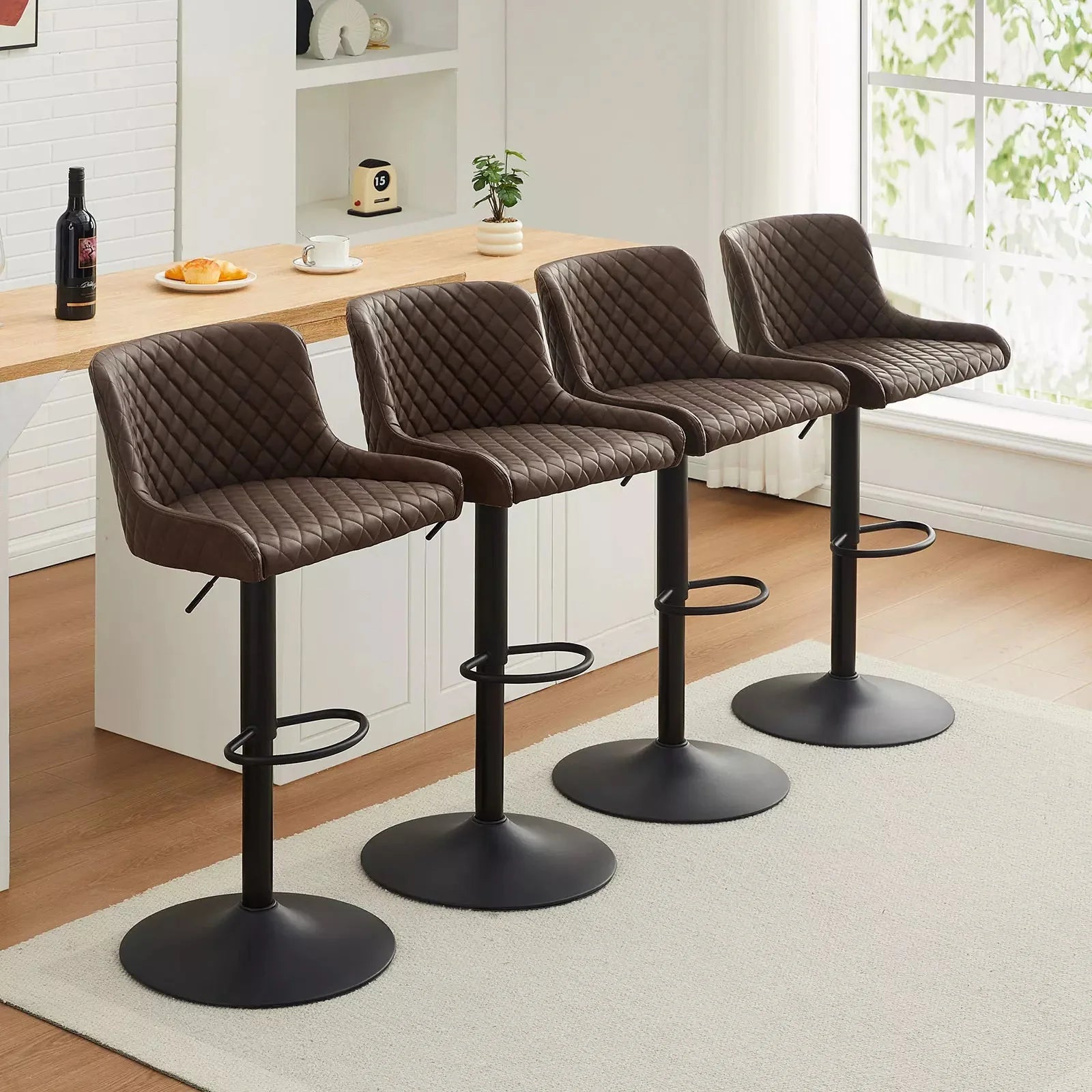 Set of 2 Dundas faux leather bar stools in brown with quilted pattern, height adjustable metal frame, and footrest.