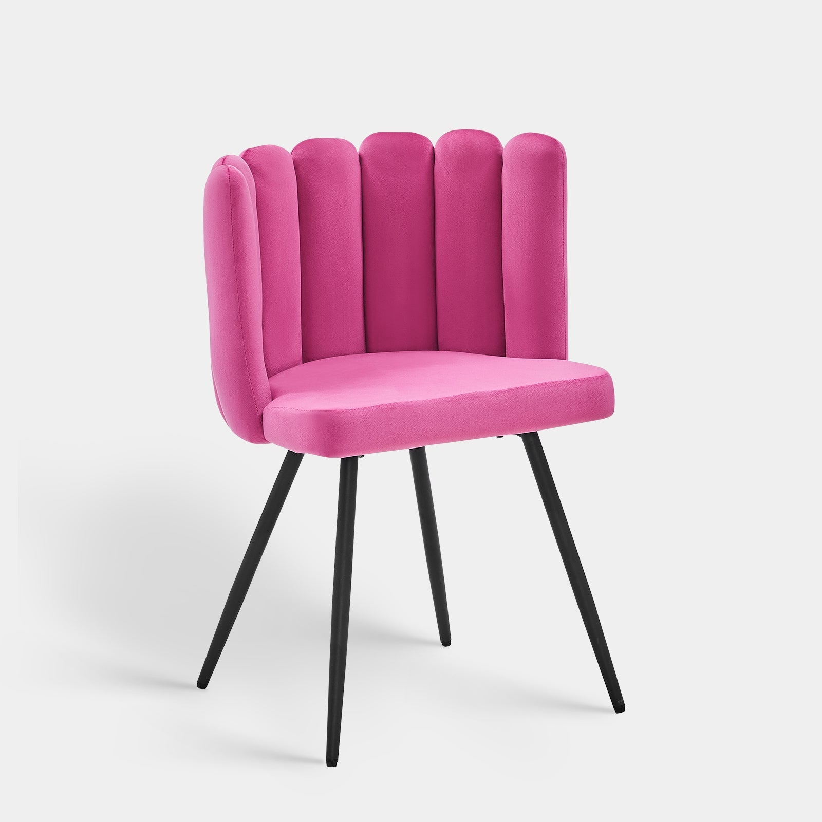Bright pink velvet accent chair with a petal curved backrest and tapered black metal legs, designed for comfort and style.