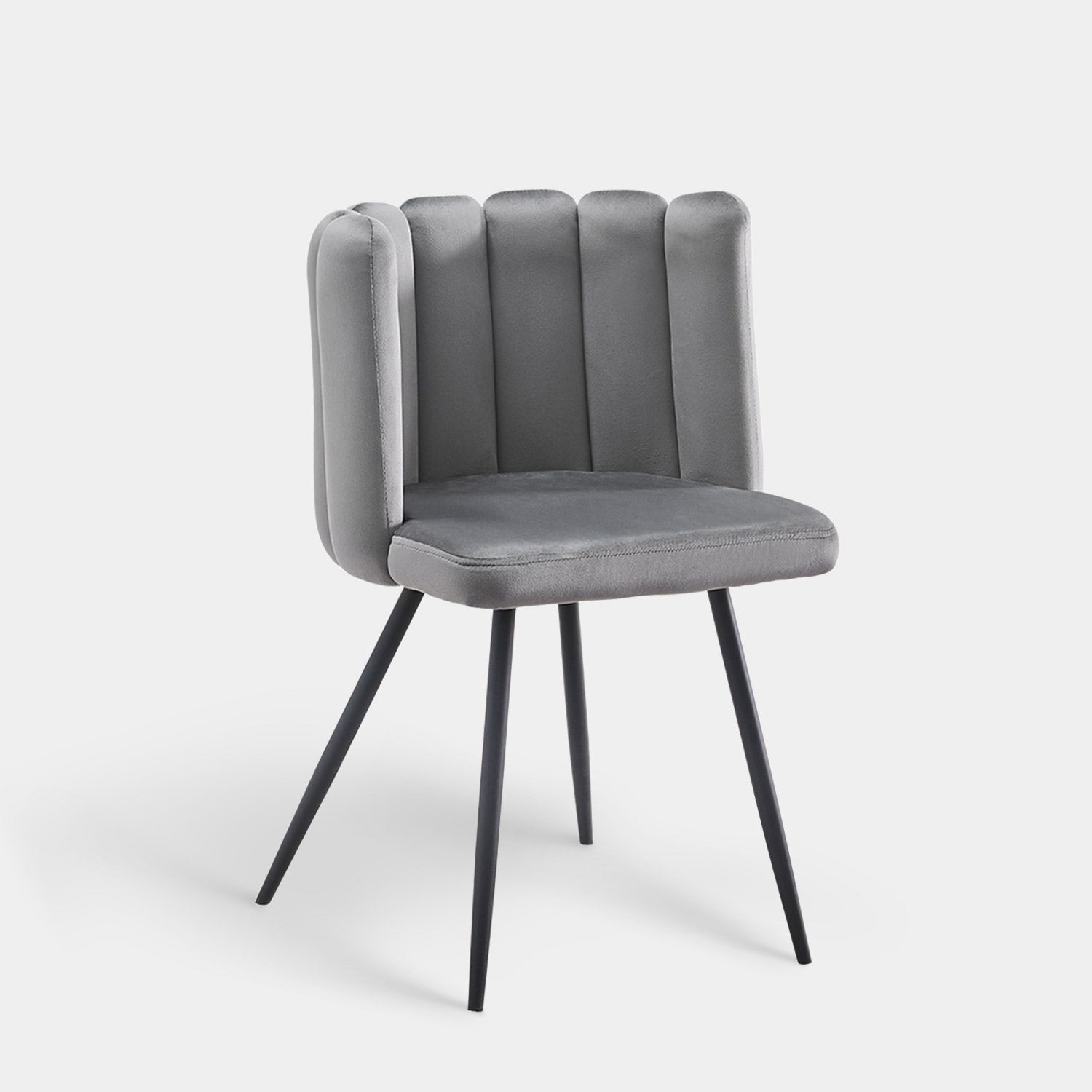 Tufted velvet accent dining chair in grey with a petal curved backrest and black tapered legs.