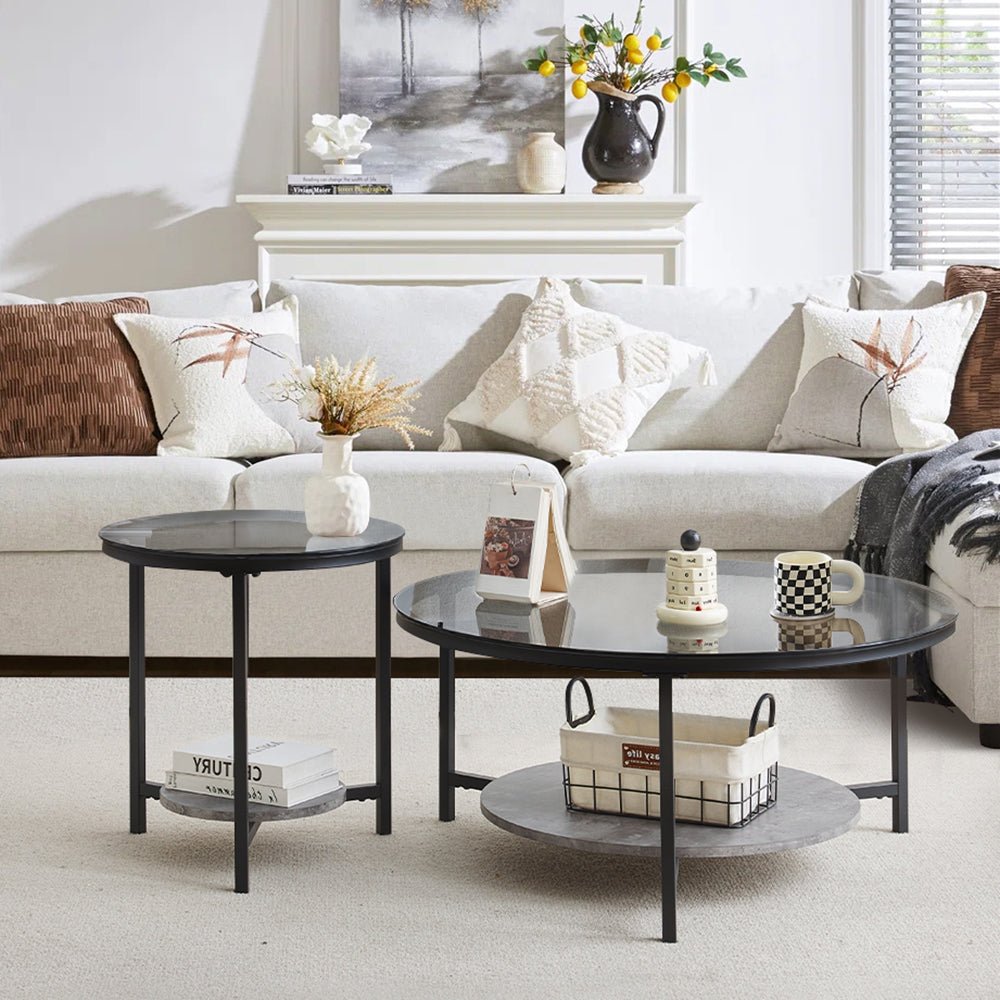 Black tempered glass coffee table set featuring a large round table and a smaller nesting table, supported by three metal legs.