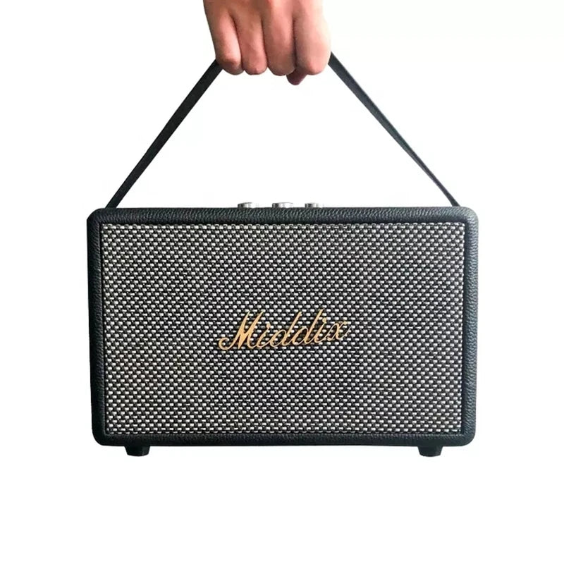 Portable Retro Bluetooth Speaker with a wooden finish and black mesh exterior, held by a hand with a strap.
